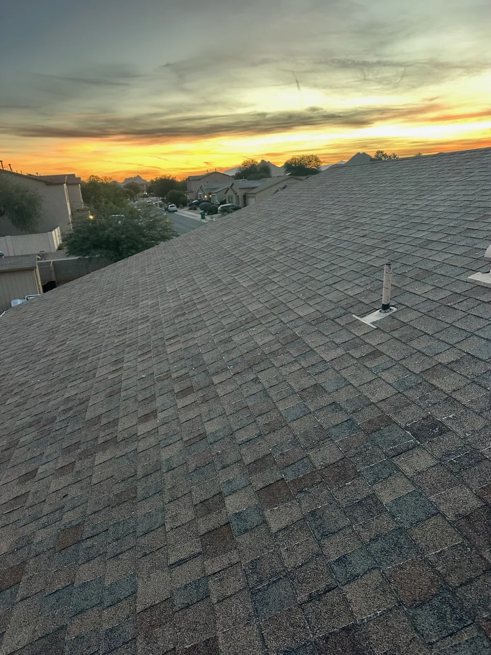 Worn shingles on an old roof at sunset, before the tear-off