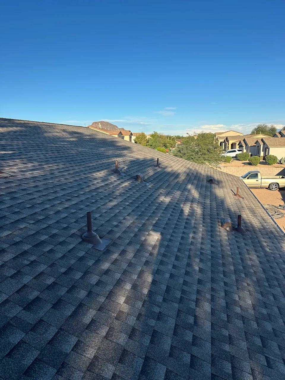 Finished charcoal shingle roof with new pipe and vent flashings