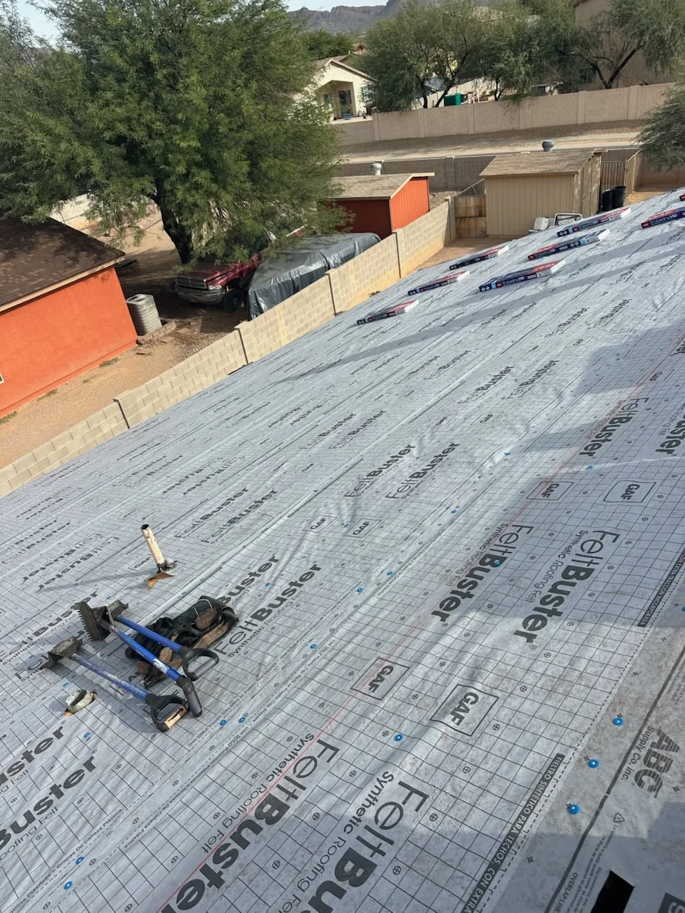 GAF FeltBuster synthetic underlayment across the roof with shingle bundles staged