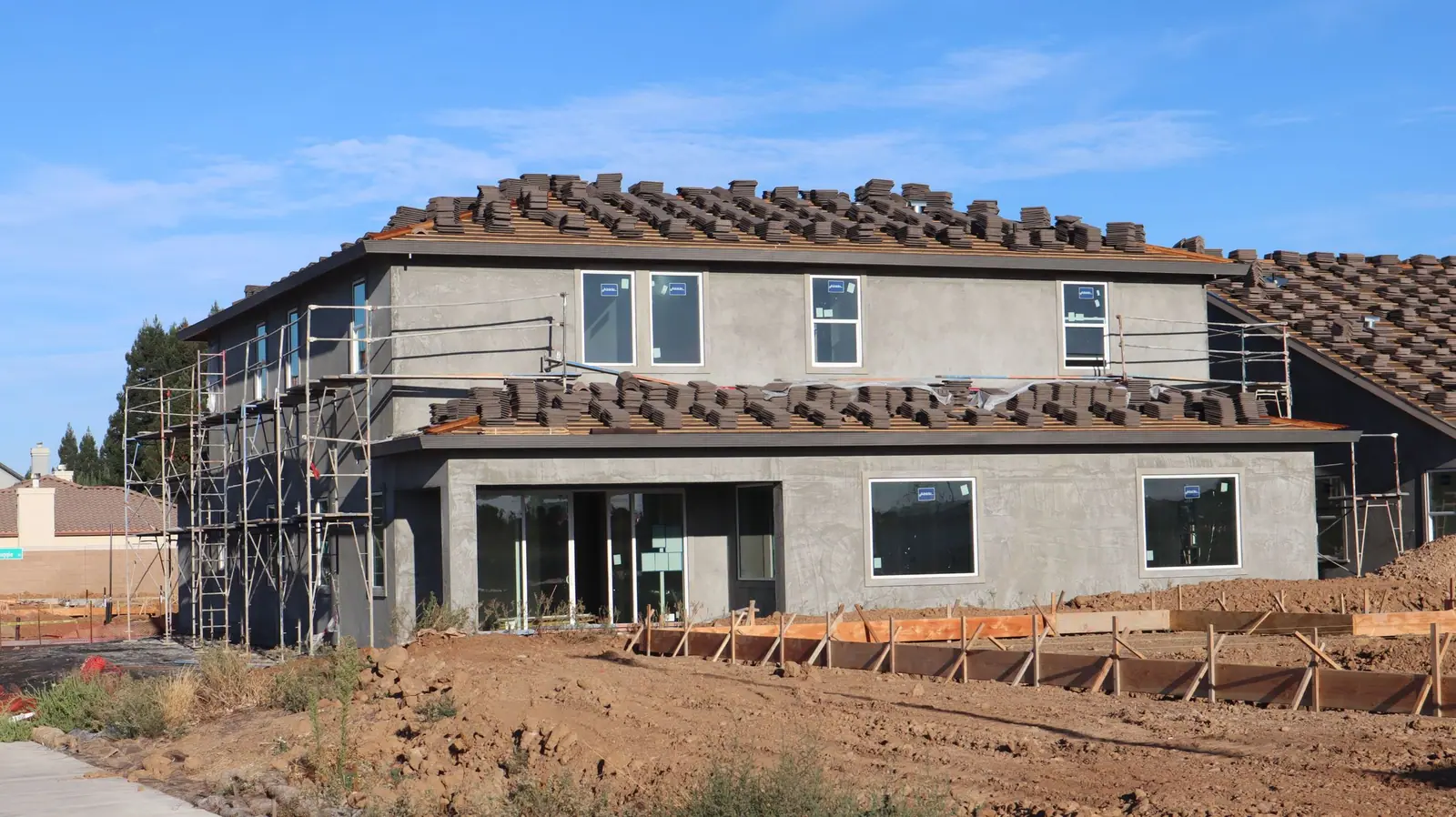 A two-storey Arizona stucco home with concrete tile loaded on the roof